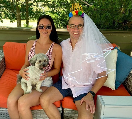 James Murray and his future wife, Melyssa Davies sitting in an outdoor sofa with Murr wearing a veil in his head.